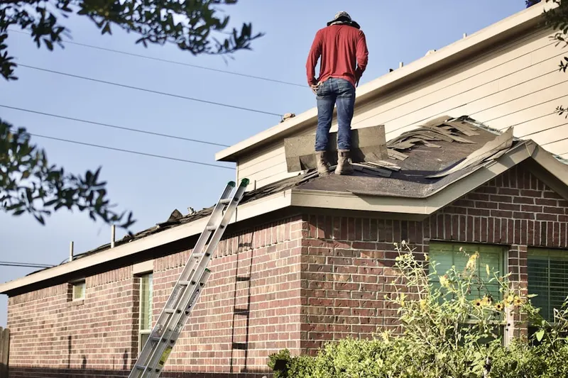 Professional roofer working on a residential roof in Weaver Corner